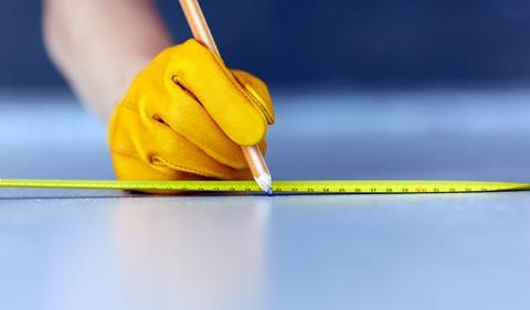 Tape measure and hand with pencil