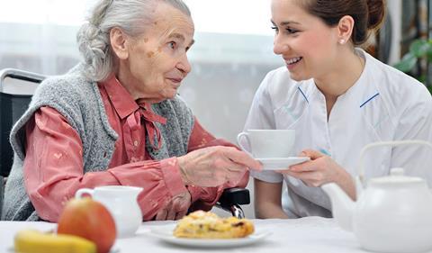 Older woman and younger woman, nurse, smiling at each other
