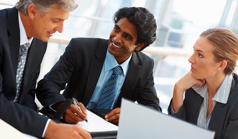 Three business people round a table