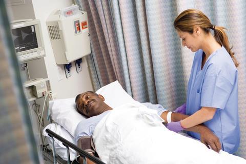Nurse attendign patient in bed
