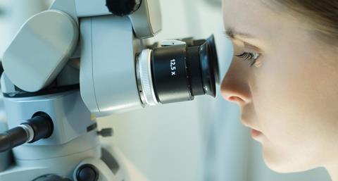 Woman looking through microscope