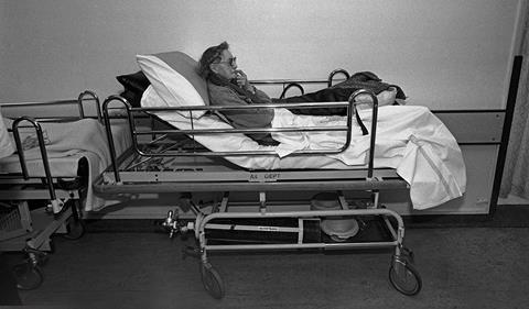 Elderly woman in a hospital trolley alone in a corridor