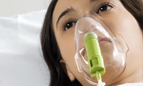 Woman lying in bed with oxygen mask