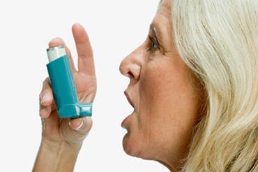 Older woman using asthma inhaler