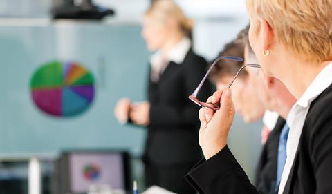 A workshop or meeting room with flip chart and people in suits