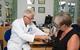 GP checks patient blood pressure